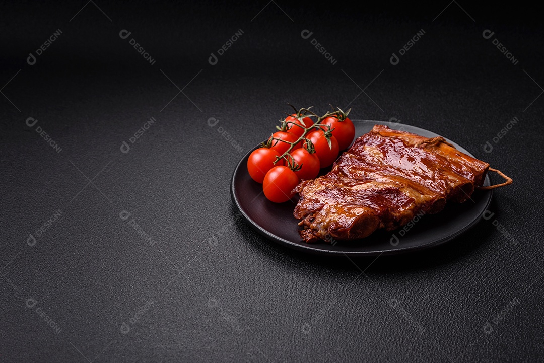 Deliciosas costelas defumadas ou grelhadas com azeitonas, especiarias e ervas sobre fundo escuro de concreto