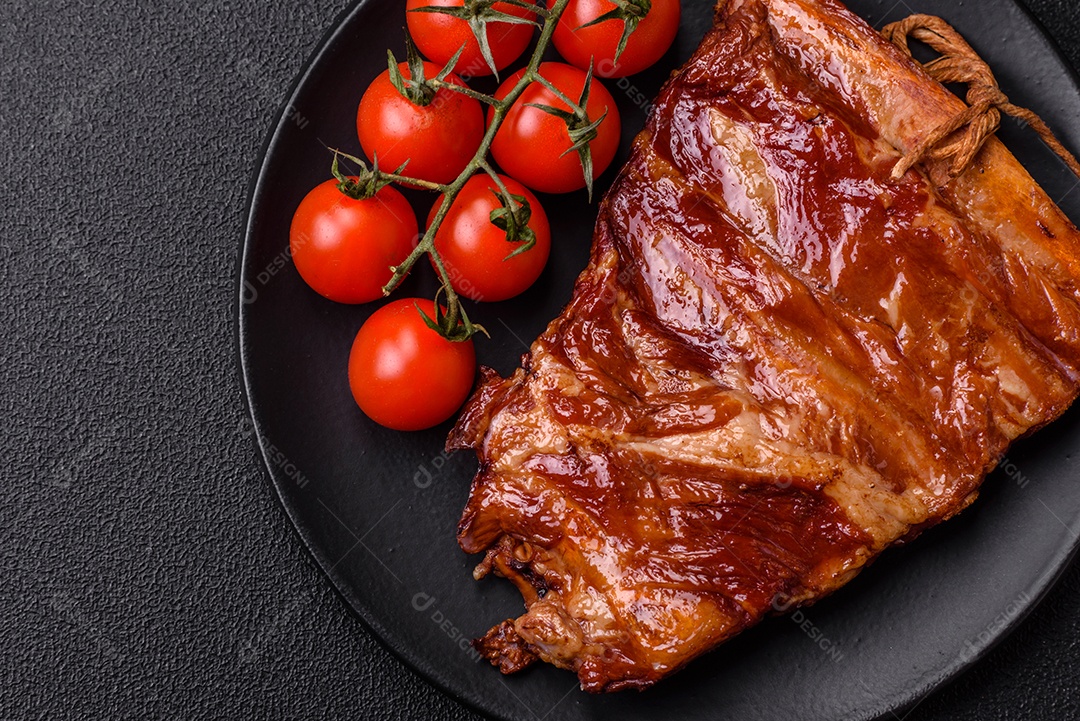 Deliciosas costelas defumadas ou grelhadas com azeitonas, especiarias e ervas sobre fundo escuro de concreto