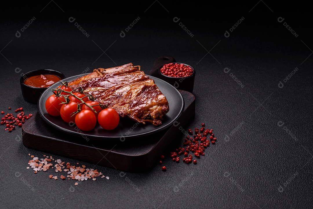 Deliciosas costelas defumadas ou grelhadas com azeitonas, especiarias e ervas sobre fundo escuro de concreto