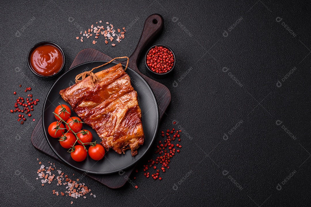 Deliciosas costelas defumadas ou grelhadas com azeitonas, especiarias e ervas sobre fundo escuro de concreto