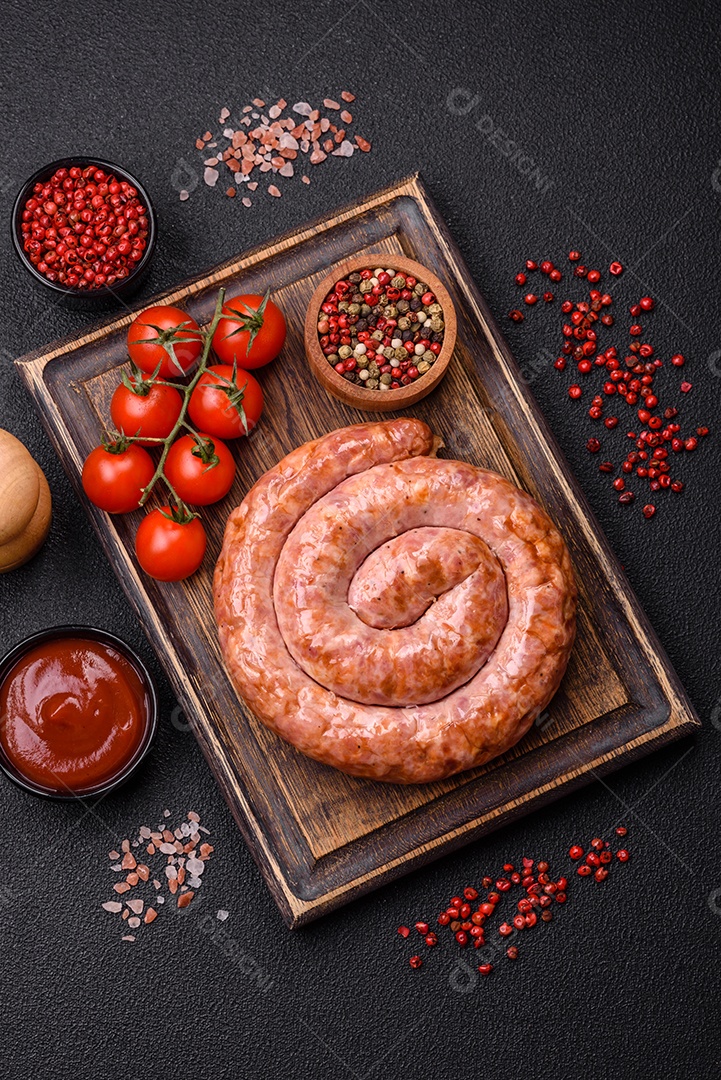 Deliciosa salsicha grelhada em forma de anel com sal, especiarias e ervas sobre fundo escuro de concreto