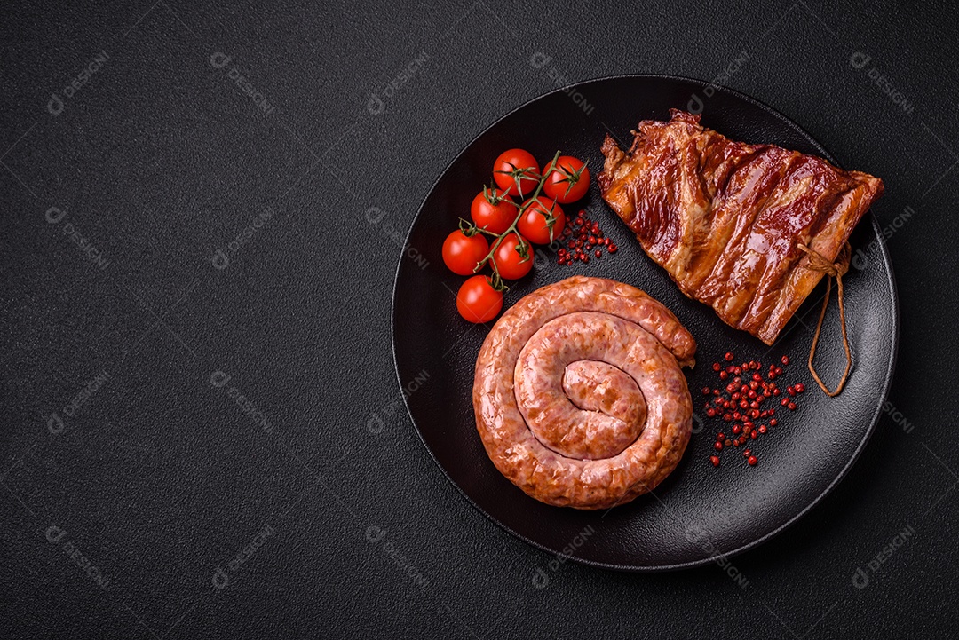 Deliciosa salsicha grelhada em forma de anel com sal, especiarias e ervas sobre fundo escuro de concreto