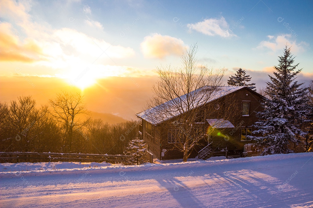 Vista de uma casa com nascer do sol atras de morro