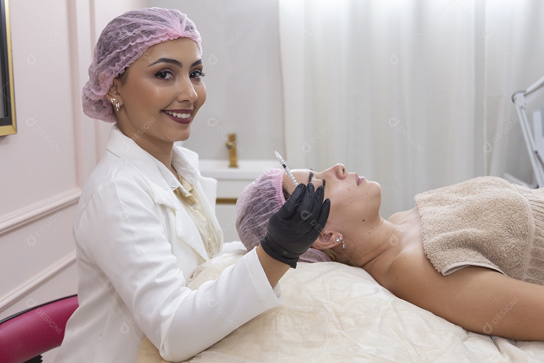 Mulher jovem realizando procedimentos estéticos em uma mulher