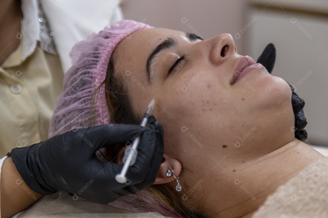 Mulher jovem realizando procedimentos estéticos em uma mulher