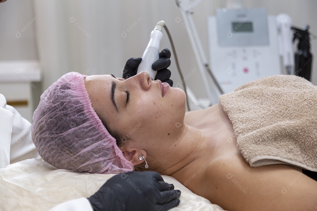 Mulher jovem realizando procedimentos estéticos em uma mulher