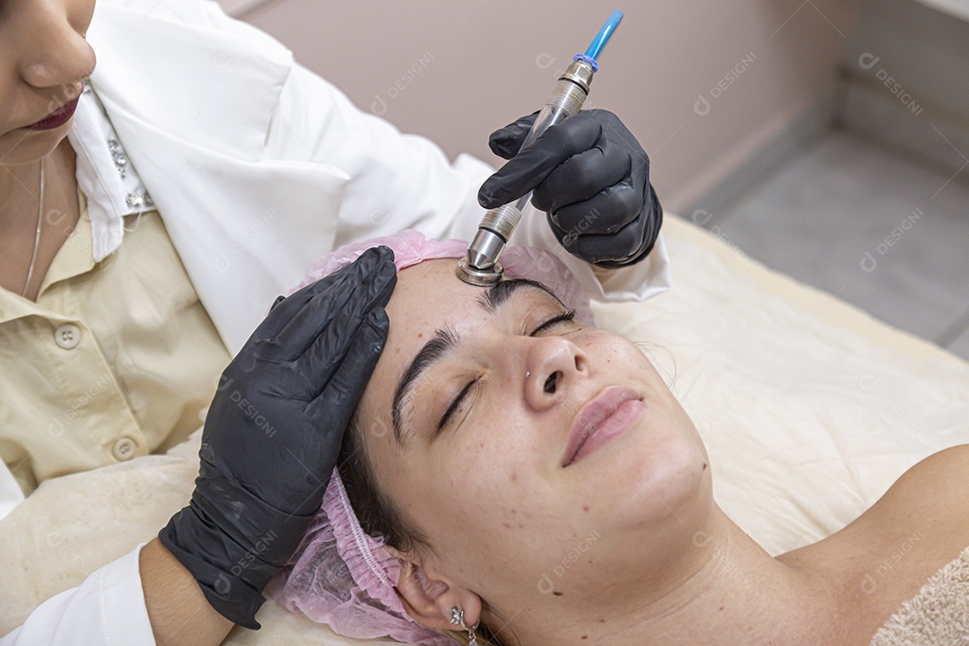 Mulher jovem realizando procedimentos estéticos em uma mulher