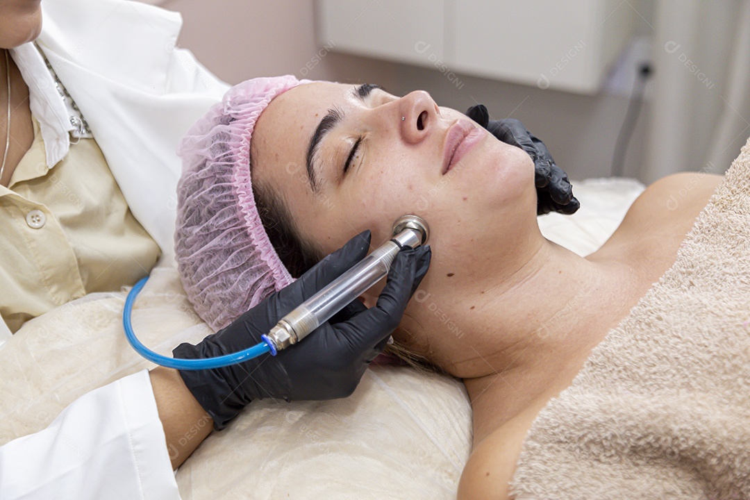 Mulher jovem realizando procedimentos estéticos em uma mulher