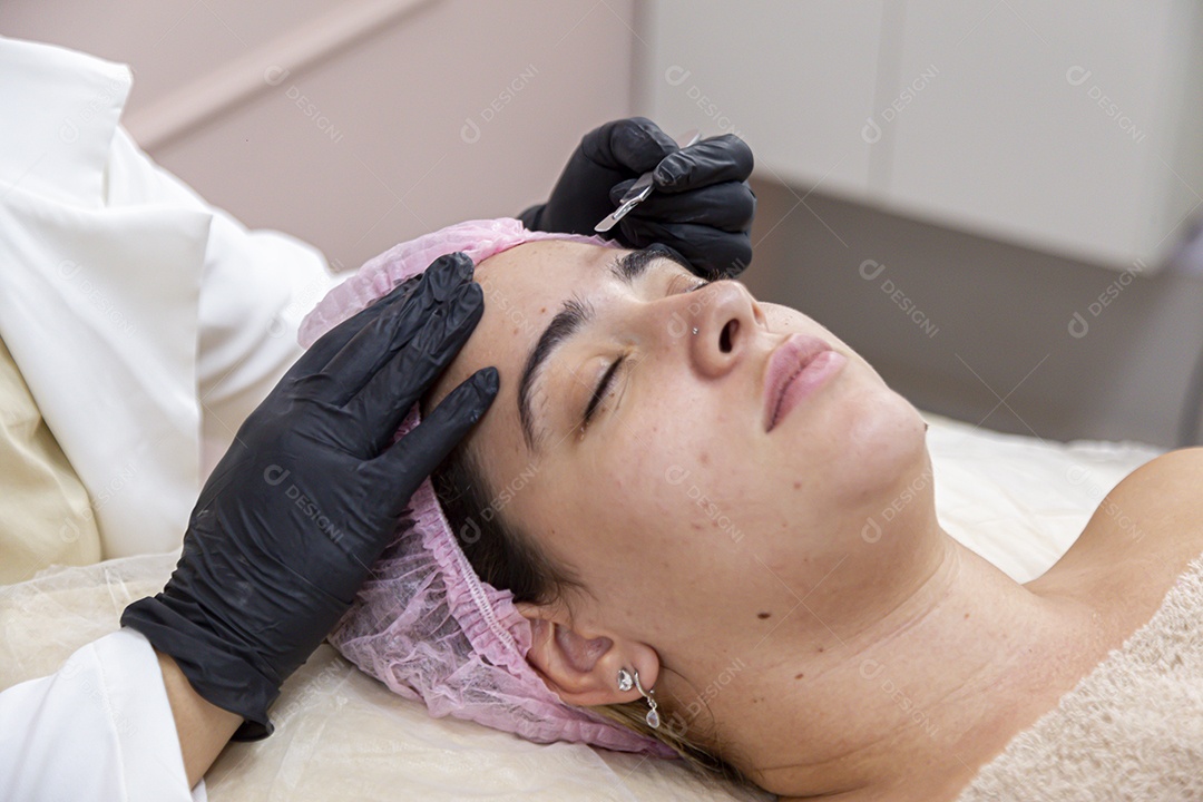 Mulher jovem realizando procedimentos estéticos em uma mulher