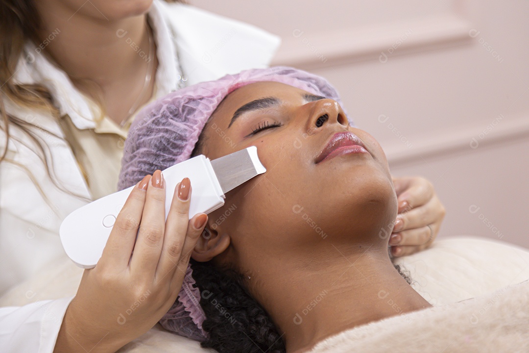 Mulher jovem realizando procedimentos estéticos em uma mulher