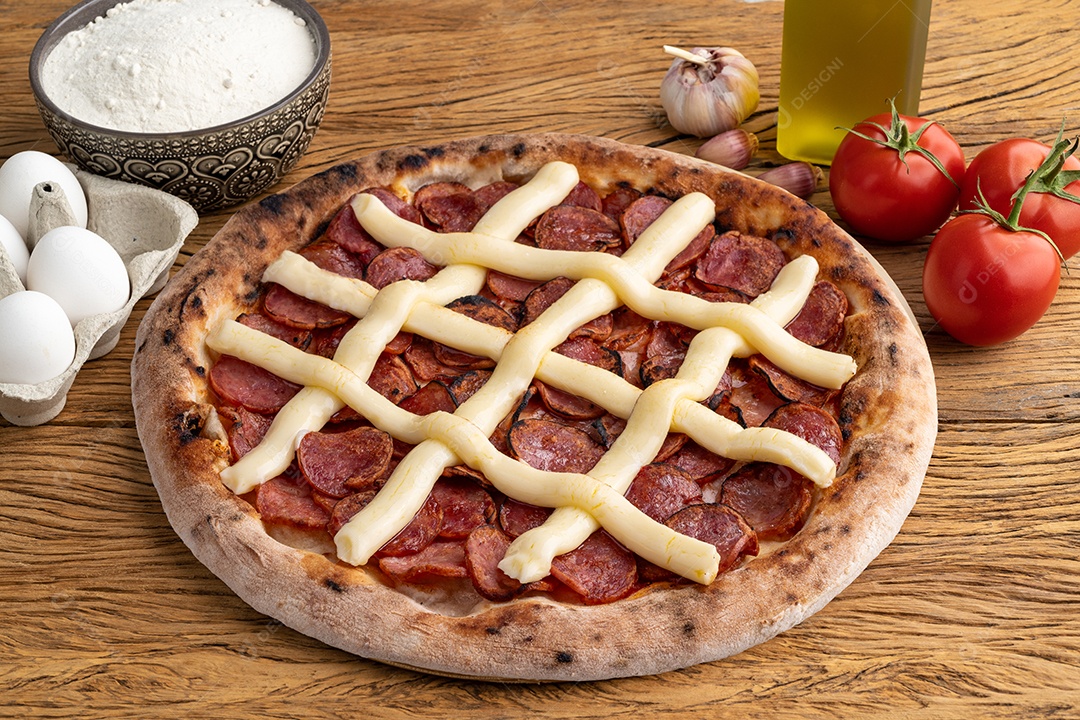 Pizza de calabresa ingredientes ao lados ovos tomate farinha azeite