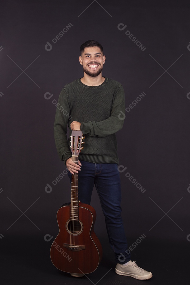 Homem jovem ao lado de violão sobre fundo isolado