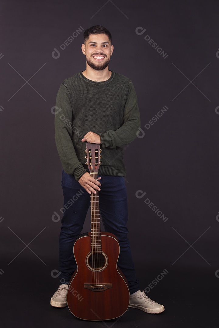 Homem jovem ao lado de violão sobre fundo isolado