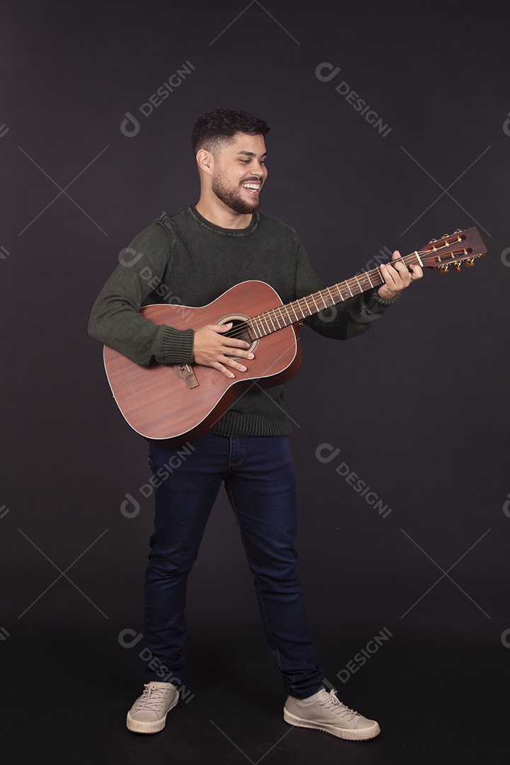 Homem jovem ao lado de violão sobre fundo isolado