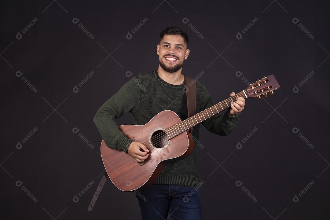 Homem jovem ao lado de violão sobre fundo isolado
