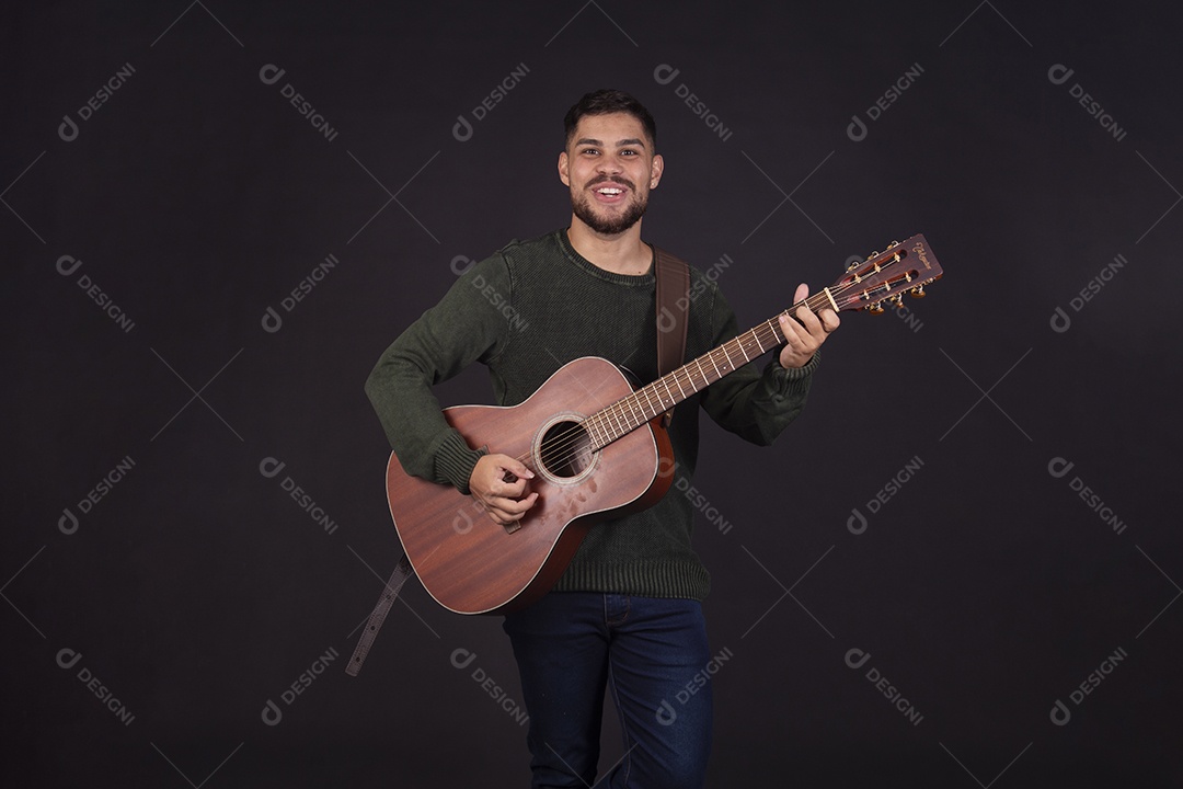 Homem jovem ao lado de violão sobre fundo isolado