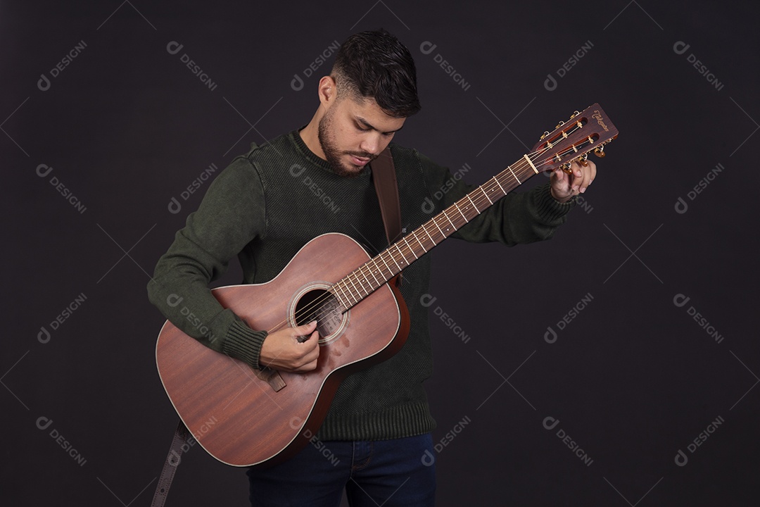 Homem jovem ao lado de violão sobre fundo isolado