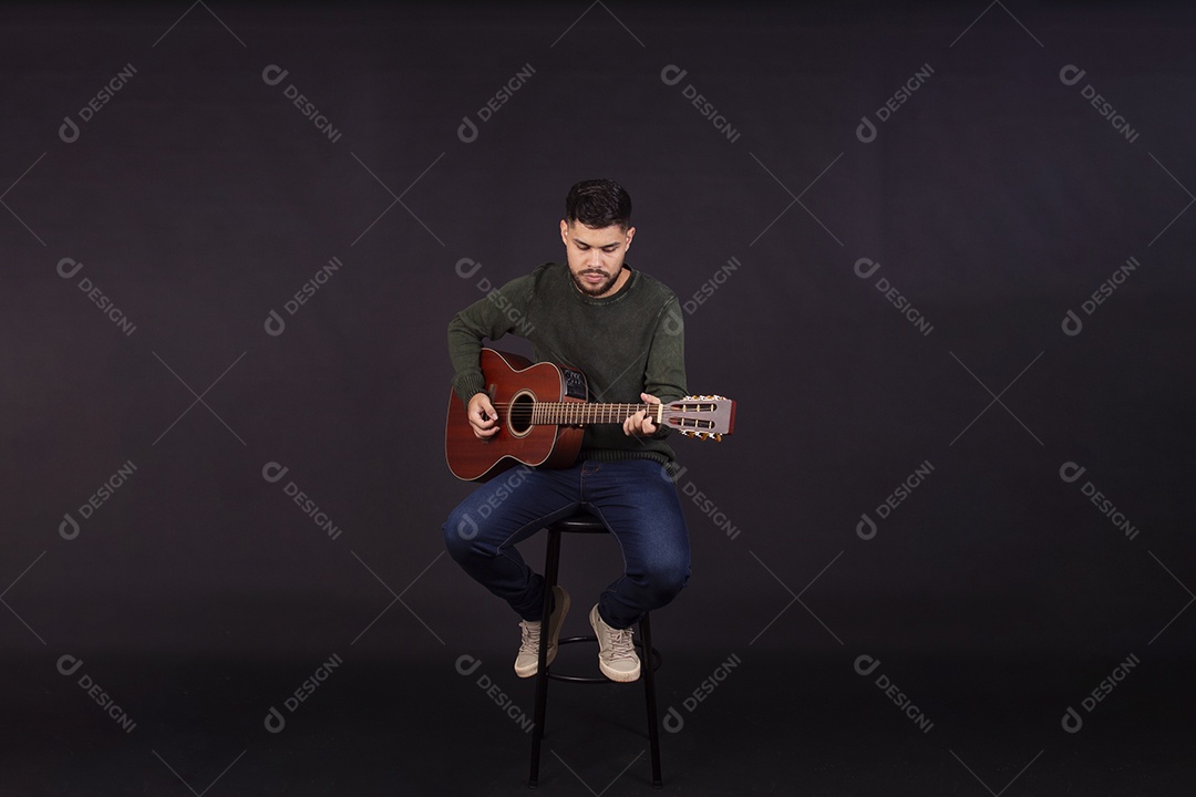 Homem jovem ao lado de violão sobre fundo isolado