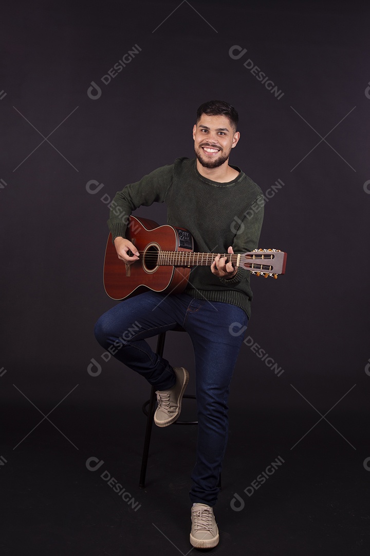 Homem jovem ao lado de violão sobre fundo isolado