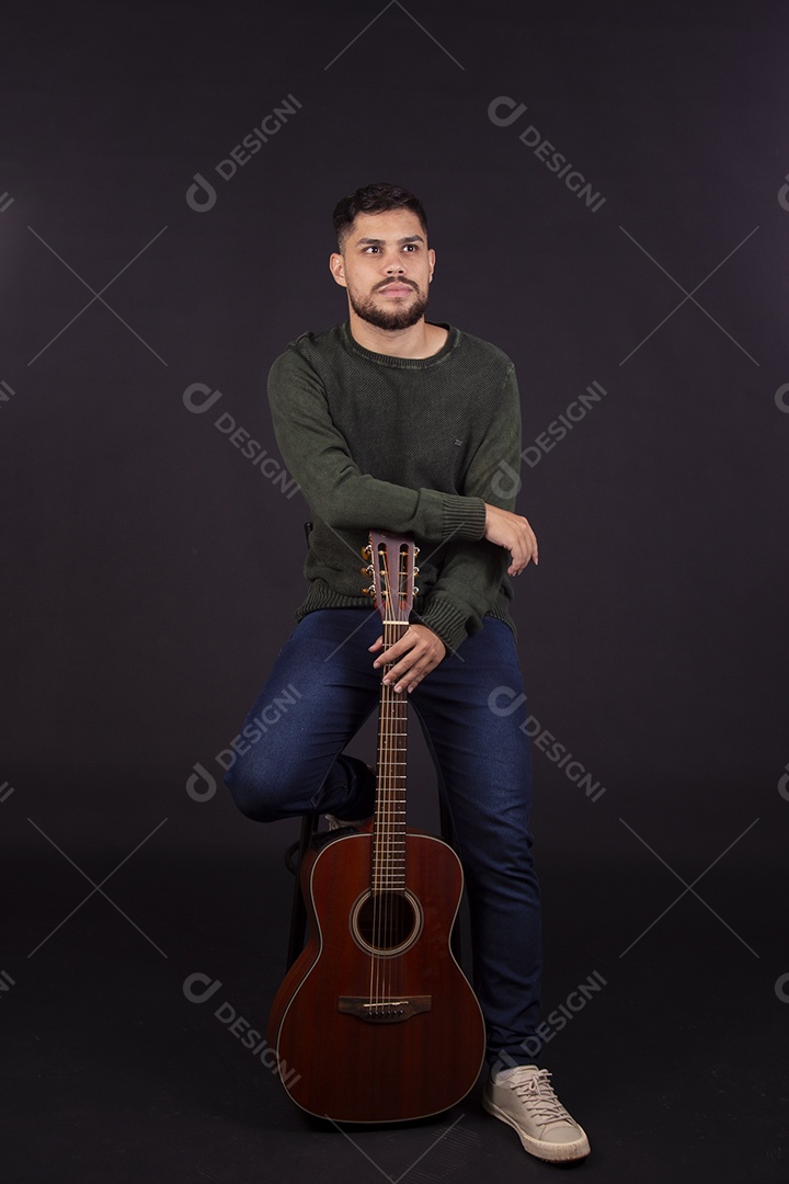 Homem jovem ao lado de violão sobre fundo isolado