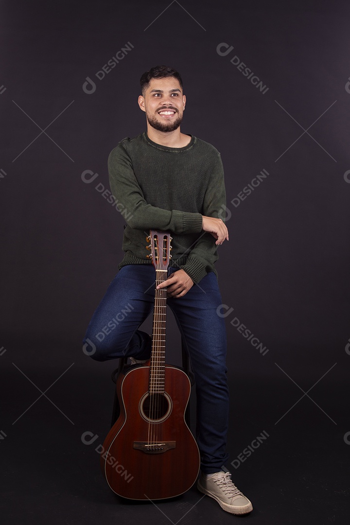 Homem jovem ao lado de violão sobre fundo isolado
