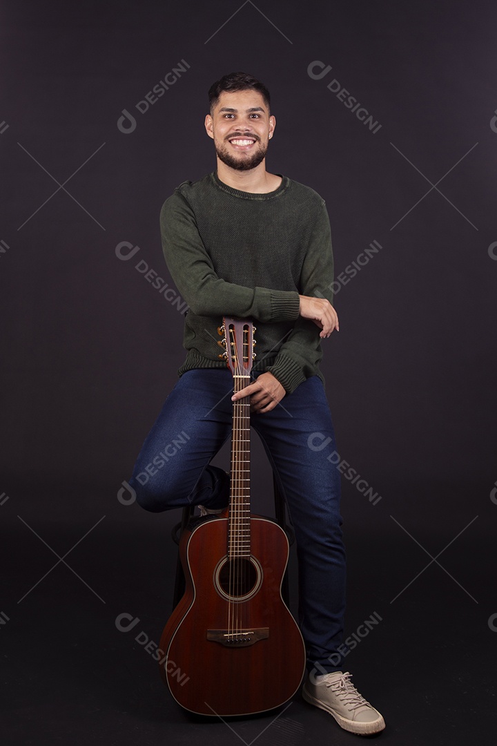 Homem jovem ao lado de violão sobre fundo isolado