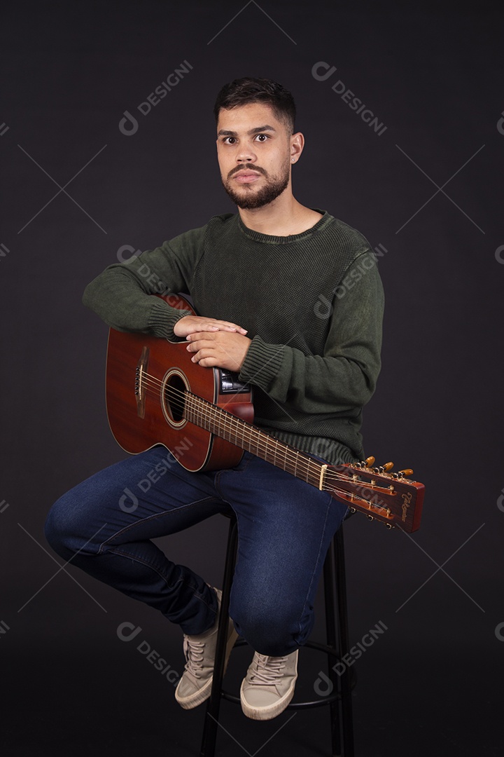 Homem jovem ao lado de violão sobre fundo isolado