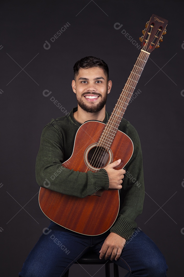 Homem jovem ao lado de violão sobre fundo isolado