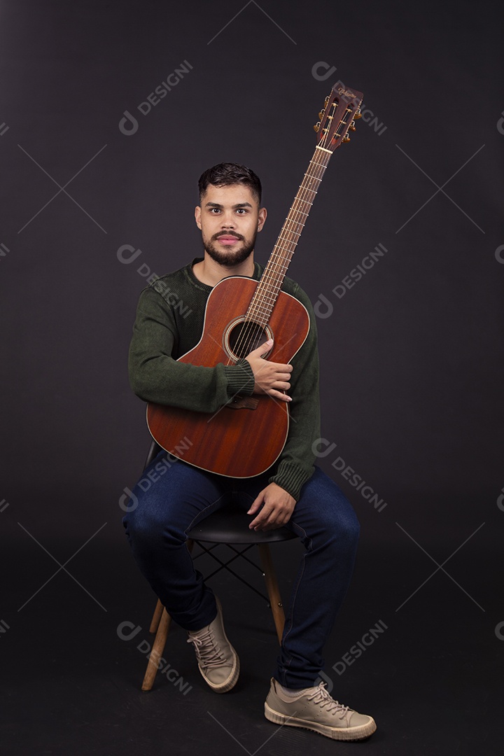 Homem jovem ao lado de violão sobre fundo isolado
