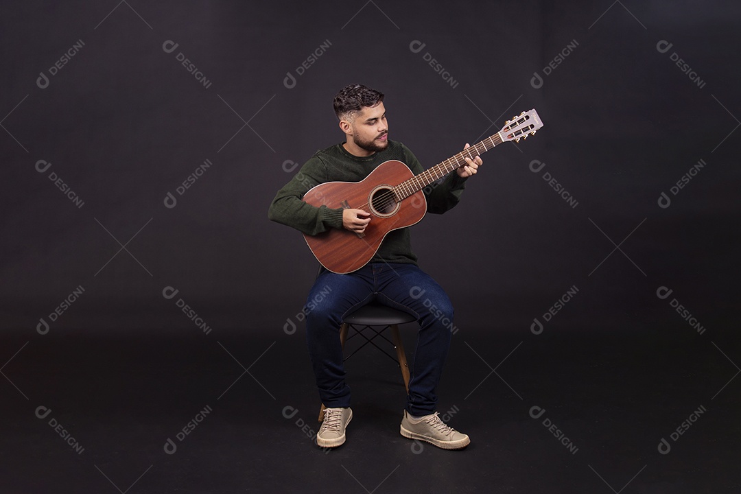 Homem jovem ao lado de violão sobre fundo isolado