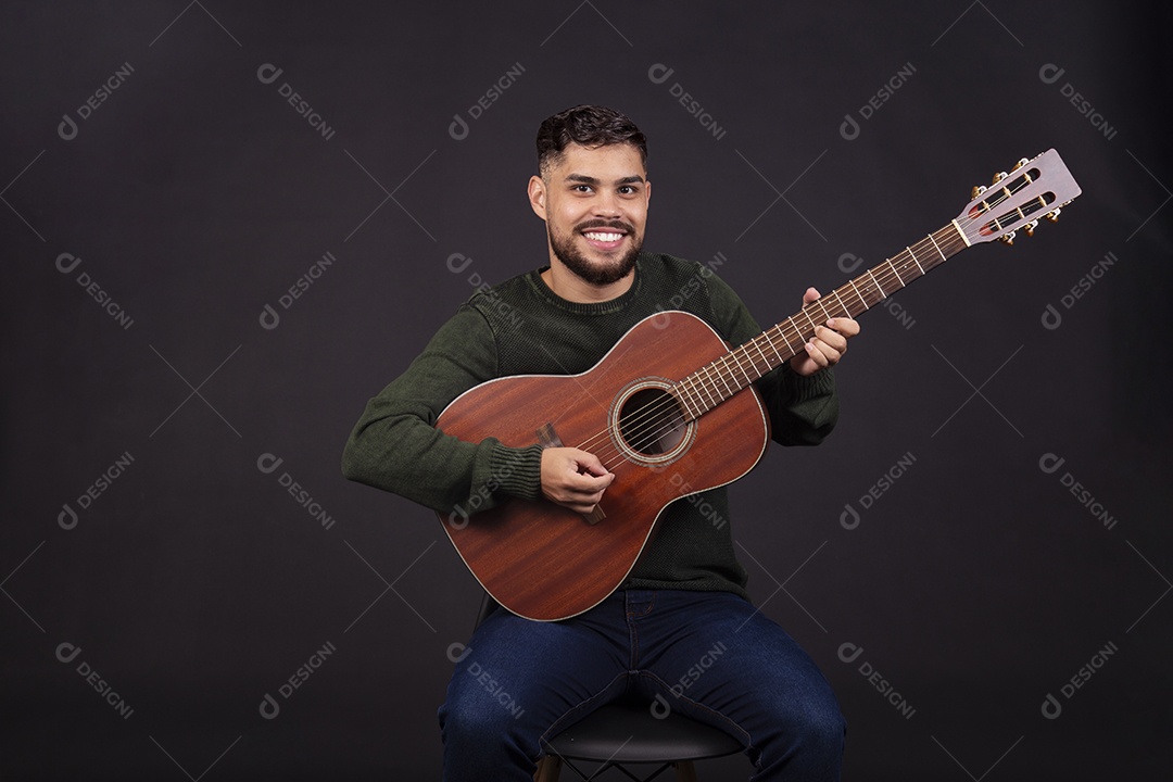 Homem jovem ao lado de violão sobre fundo isolado