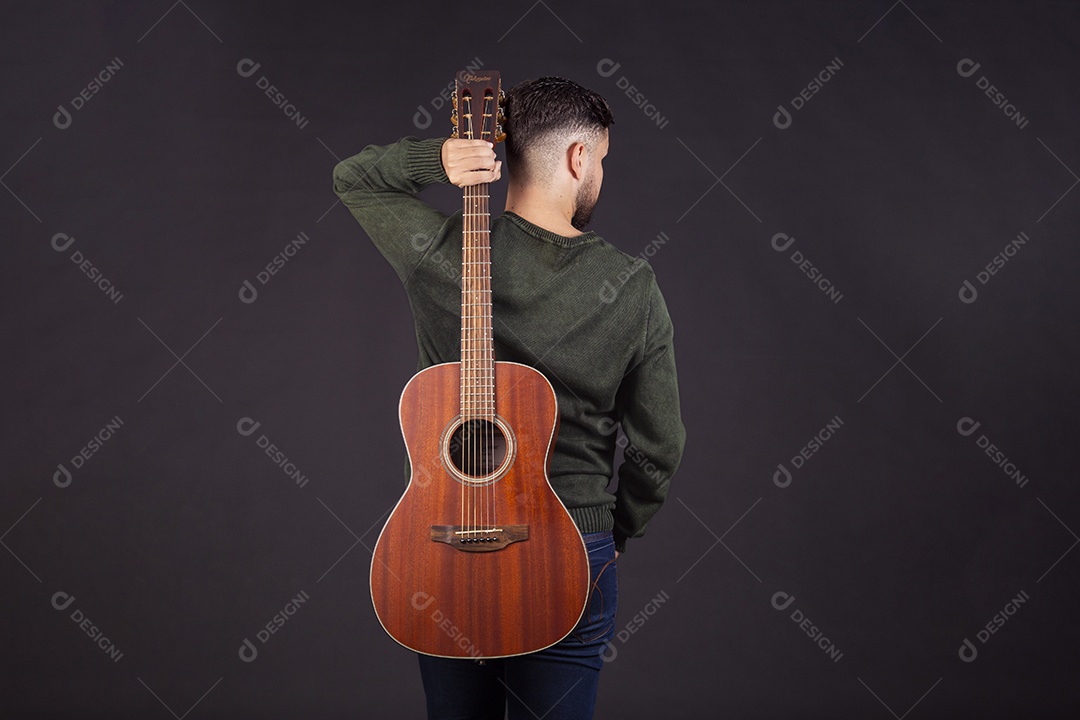 Homem jovem ao lado de violão sobre fundo isolado
