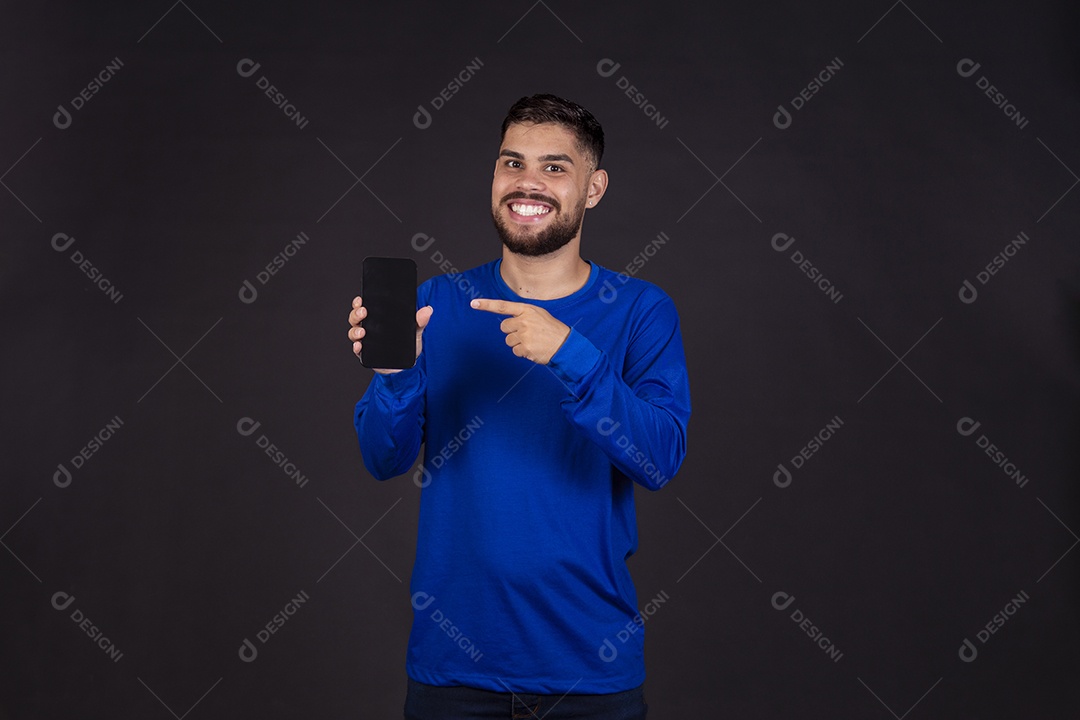 Homem jovem garoto barbudo sobre fundo isolado segurando celular smartphone