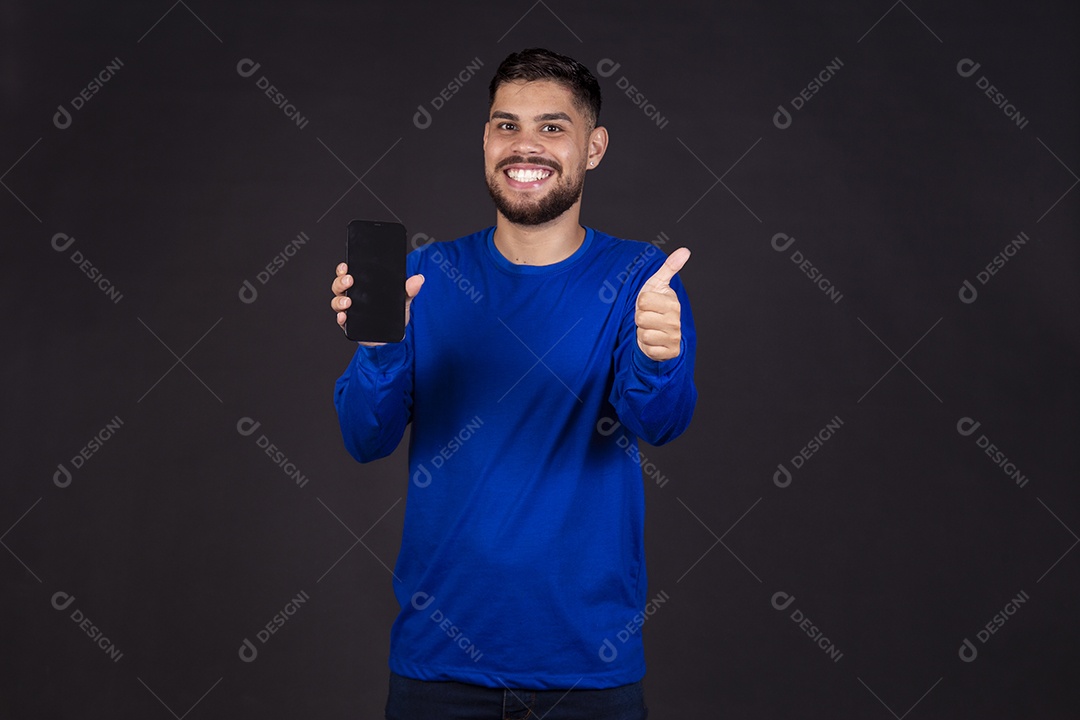 Homem jovem garoto barbudo sobre fundo isolado segurando celular smartphone