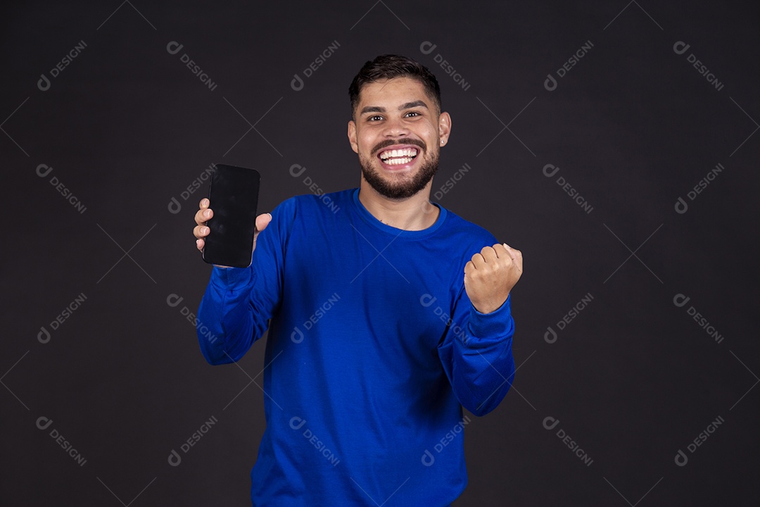 Homem jovem garoto barbudo sobre fundo isolado segurando celular smartphone