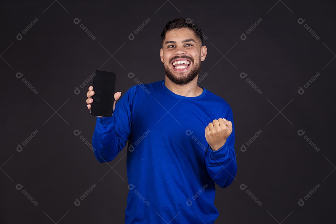 Homem jovem garoto barbudo sobre fundo isolado segurando celular smartphone