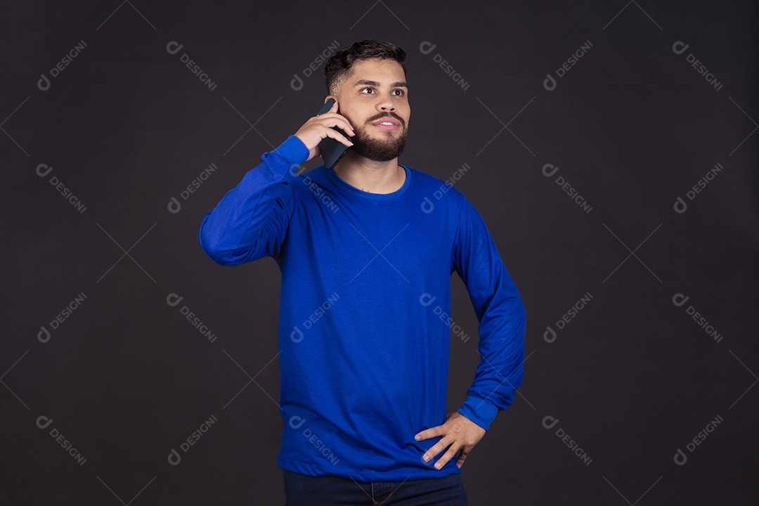 Homem jovem garoto barbudo sobre fundo isolado segurando celular smartphone