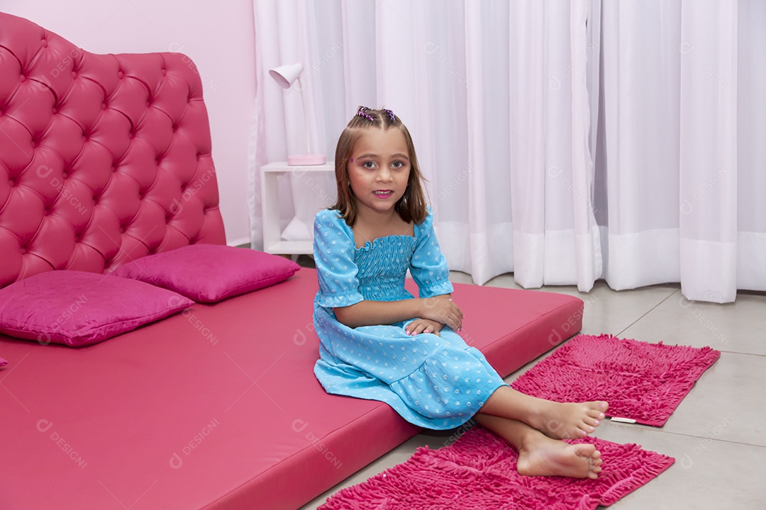 Linda garota jovem sentado sobre cama