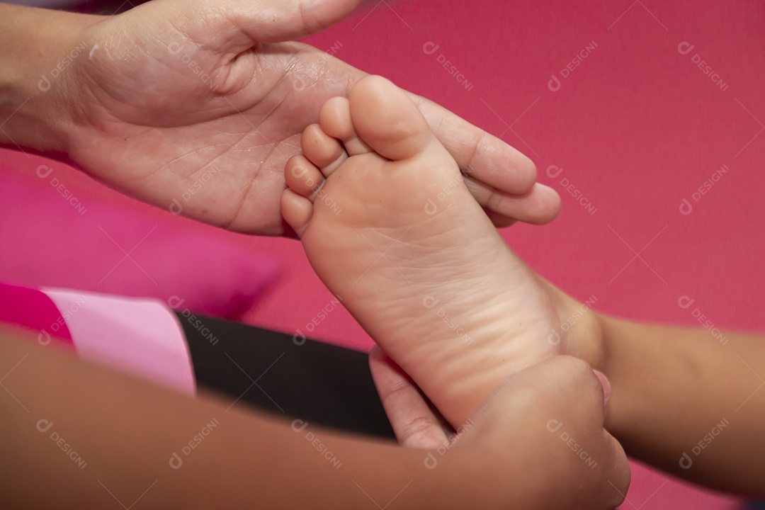 Mulher pintando a unha dos pés de de uma pessoa