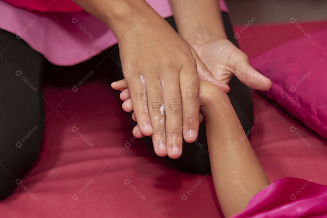 Mulher pintando a unha das mãos de de uma pessoa