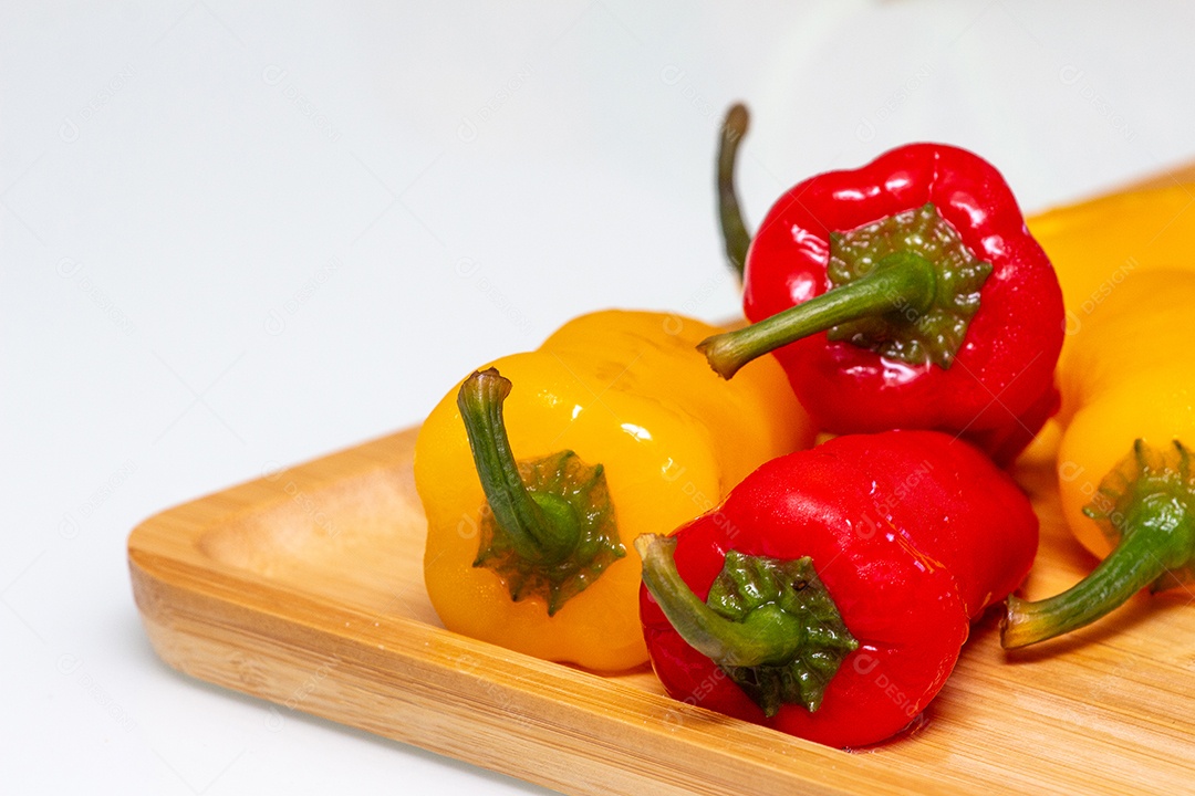 Pimentões amarelos e vermelhos na mesa de madeira