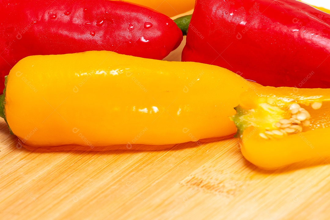 Pimentões amarelos e vermelhos na mesa de madeira