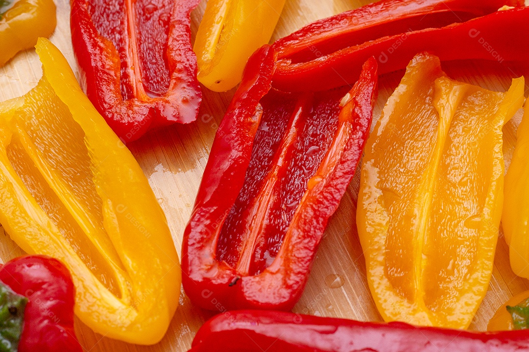 Pimentões amarelos e vermelhos na mesa de madeira