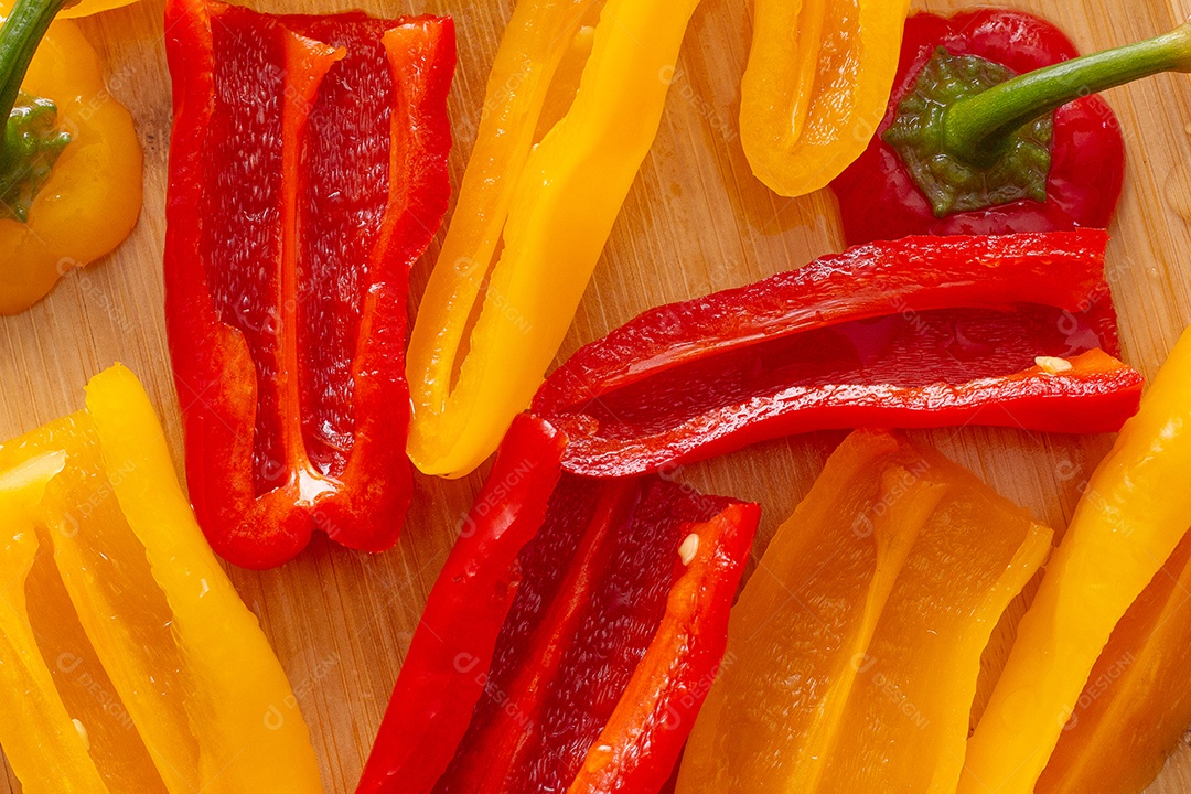 Pimentões amarelos e vermelhos na mesa de madeira
