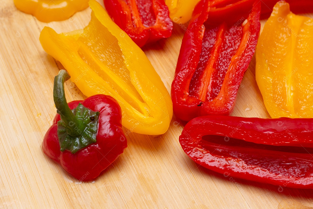Pimentões amarelos e vermelhos na mesa de madeira