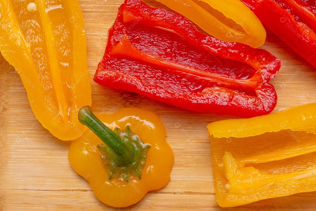 Pimentões amarelos e vermelhos na mesa de madeira