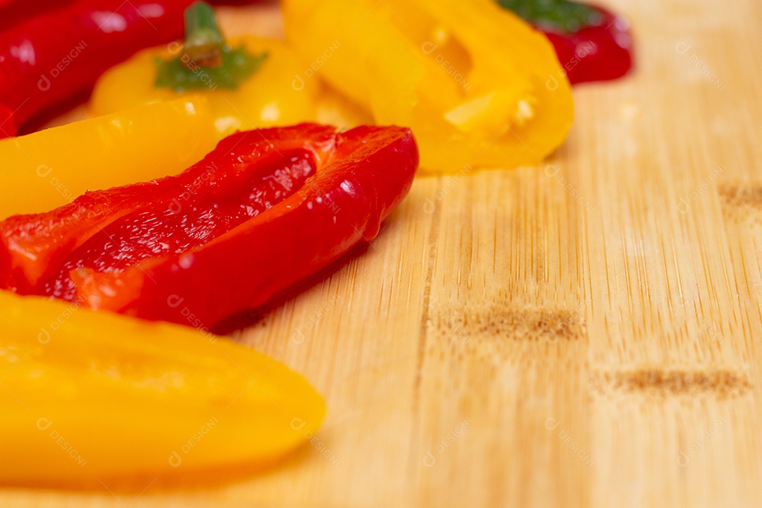 Pimentões vermelhos e amarelos sobre uma tábua