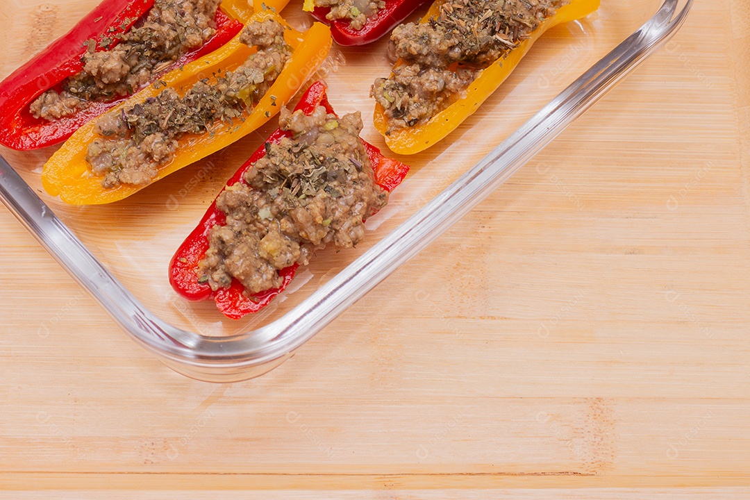 Pimentões amarelos e vermelhos com delicioso recheio de carne moída na mesa de madeira