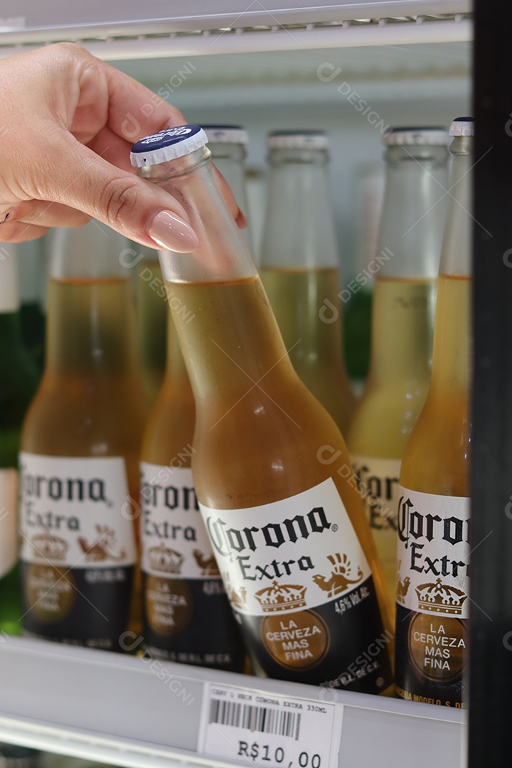 Linda mão de mulher retirando bebida alcoólica de câmara fria