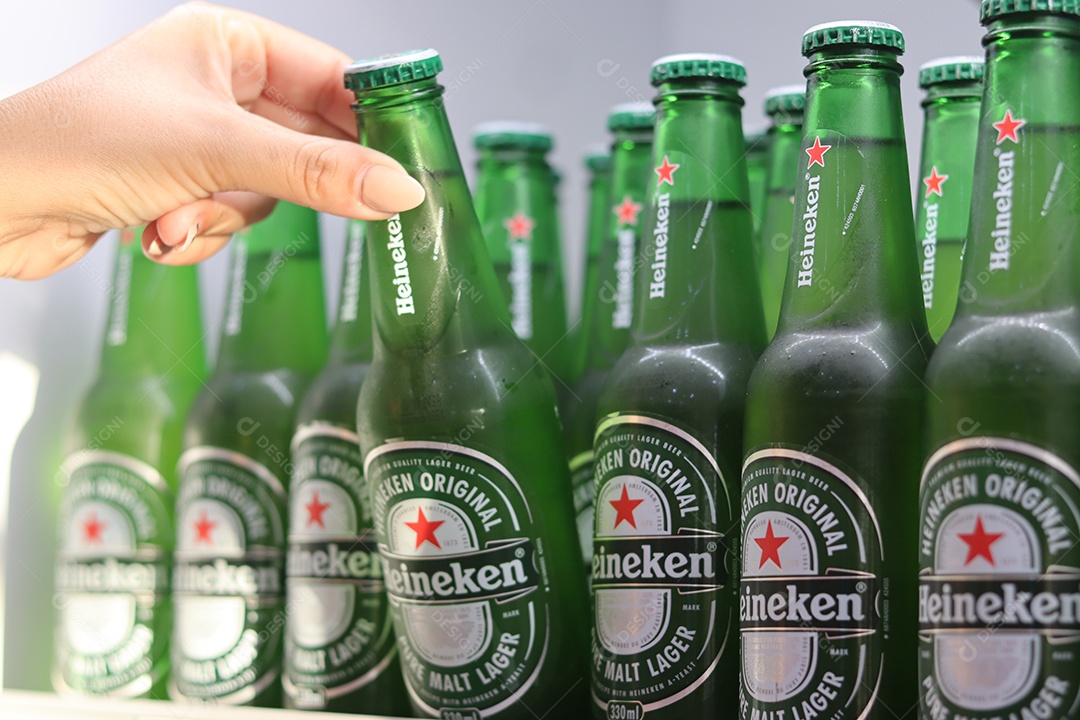 Linda mão de mulher retirando bebida alcoólica de câmara fria